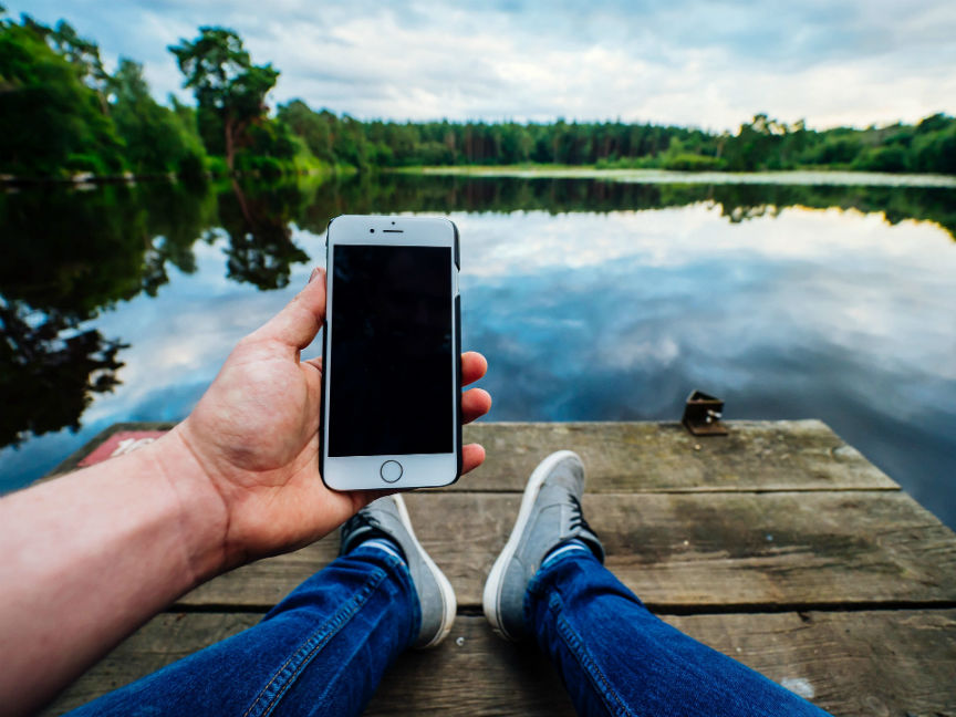 Person holding iPhone on dock