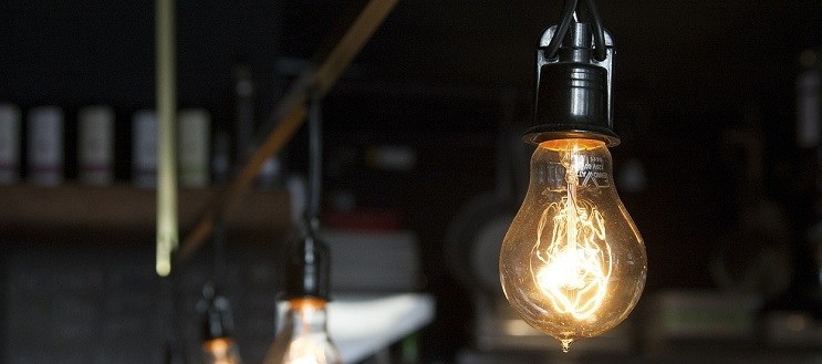 A lit lightbulb in the middle of a dark shop.